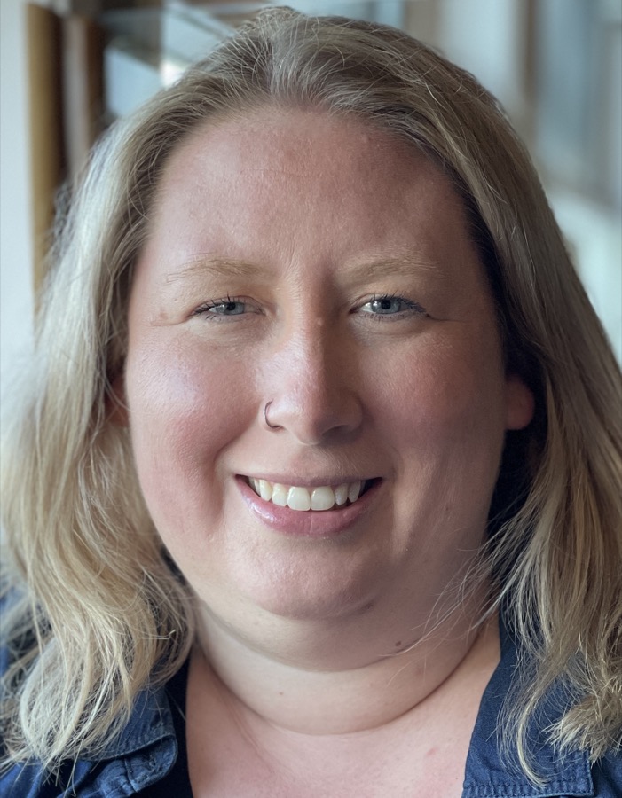 Dr. Ashley Tuttle, smiling, in a denim shirt